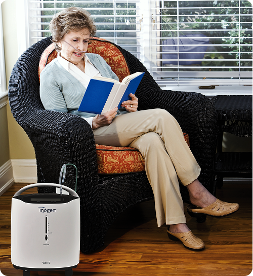 Woman reading in her living room with a Voxi 5 Oxygen Concentrator