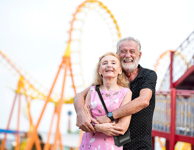 Couple at an amusement park with the Inogen Rove 4