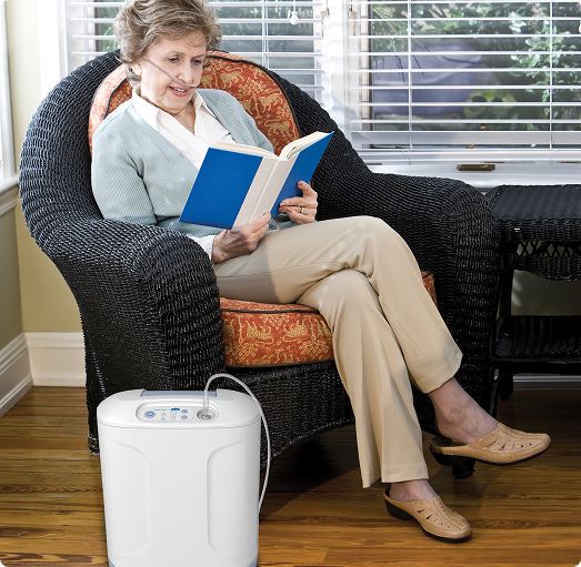 Woman reading in living room with Inogen At Home