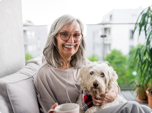 Woman using an Inogen At Home with dog in living room