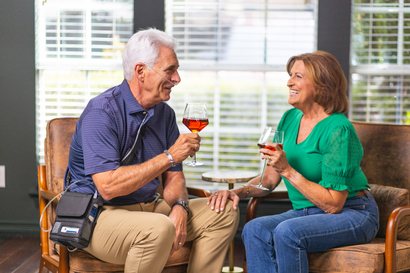 Two people sitting and talking, demonstrating portable oxygen use